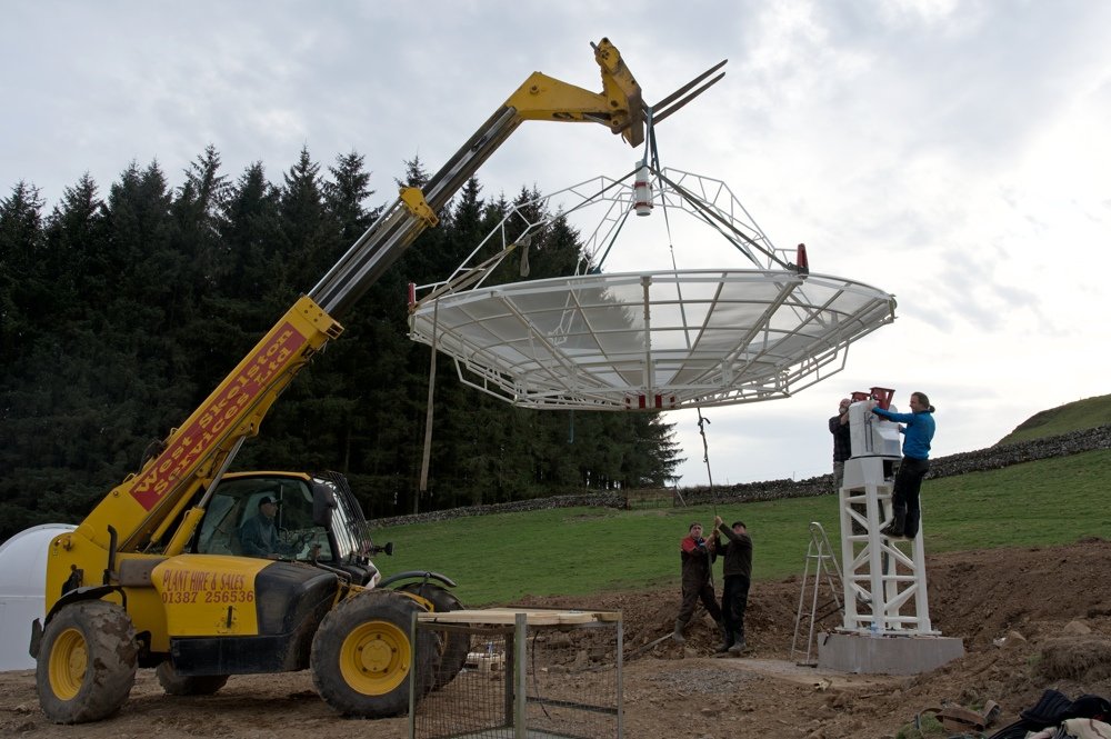 Radiotelescopio SPIDER 500A installato in Scozia: con l'aiuto di una macchina per il sollevamento, l'antenna viene installata sulla montatura